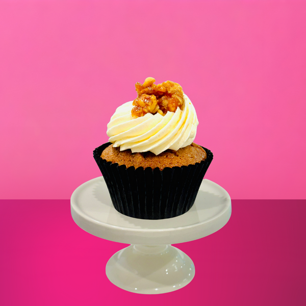 Carrot and walnut cupcake topped with cream cheese buttercream, walnut praline crumble, and a mini fondant carrot.