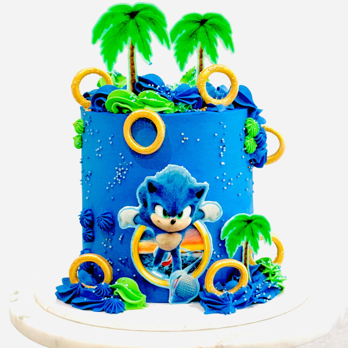 Sonic the Hedgehog cake with blue frosting, themed toppers, gold rings, and colourful decorations. A fun birthday cake for Sonic fans.
