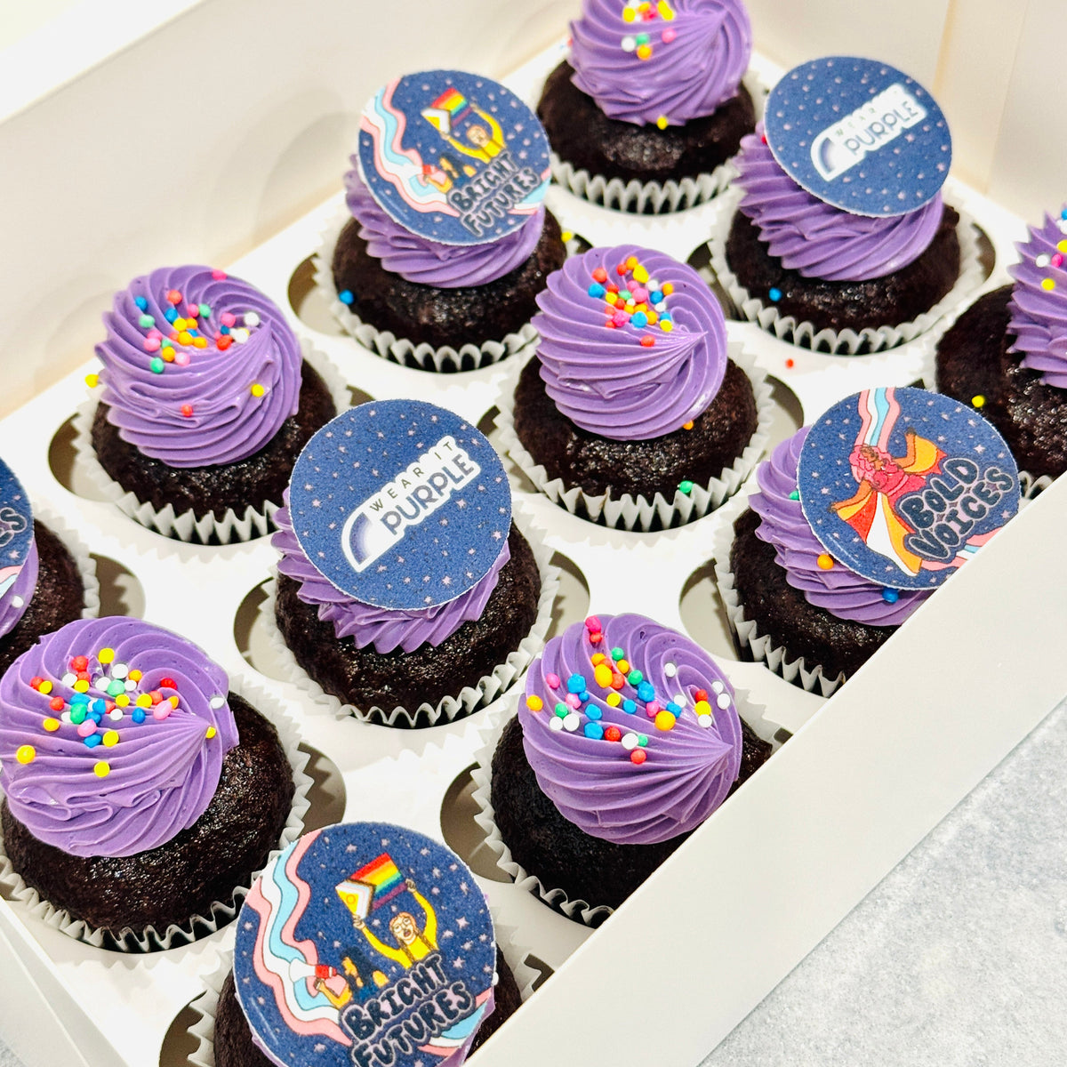 Box of Wear it Purple Mini Cupcakes with purple frosting