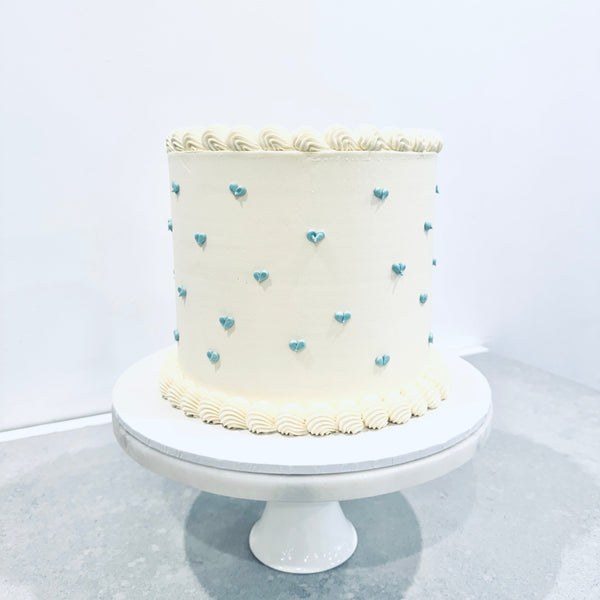 White buttercream cake with mini blue buttercream hearts