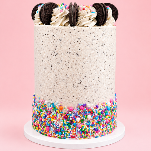 Cake with colorful sprinkles and Oreo cookies on a pink background
