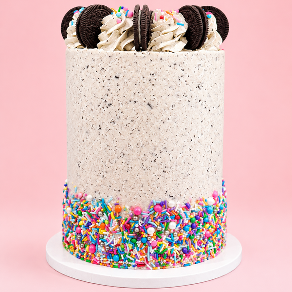 Cake with colorful sprinkles and Oreo cookies on a pink background