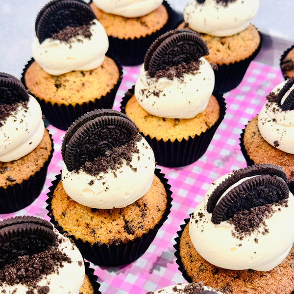 Cupcakes with Oreo cookies and cream frosting on a pink checkered background