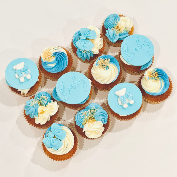 Decorative cupcakes with blue and white icing on a light background